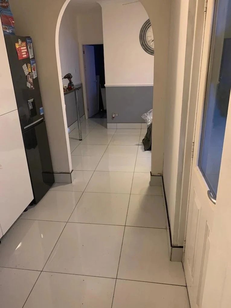 Large grey floor tiles laid through a hallway