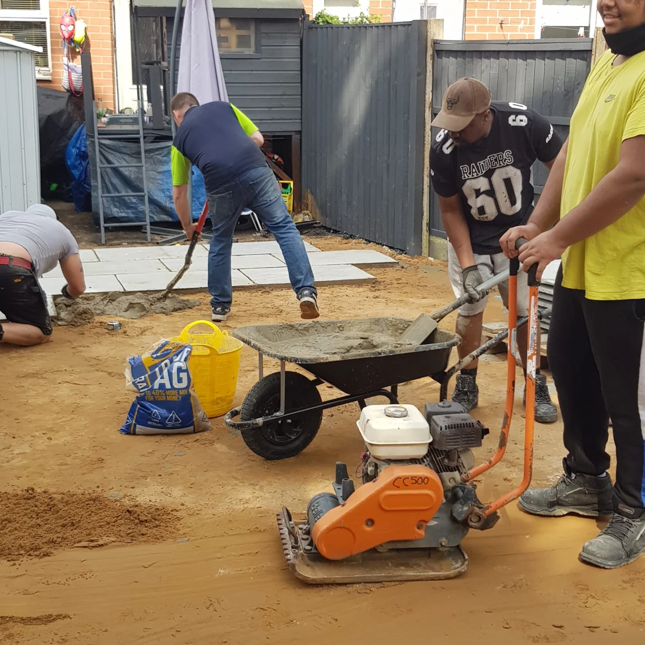 Patio groundwork with tradespeople and a compactor