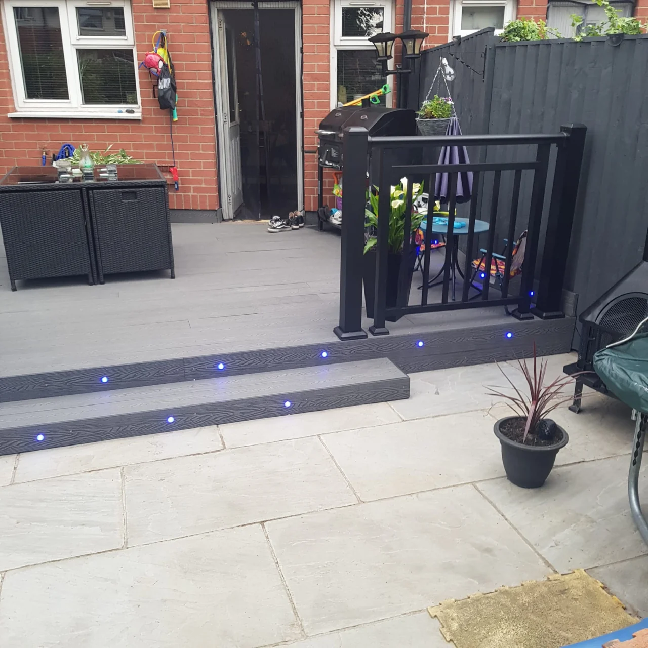 Finished paved patio and raised decking outside a brick house